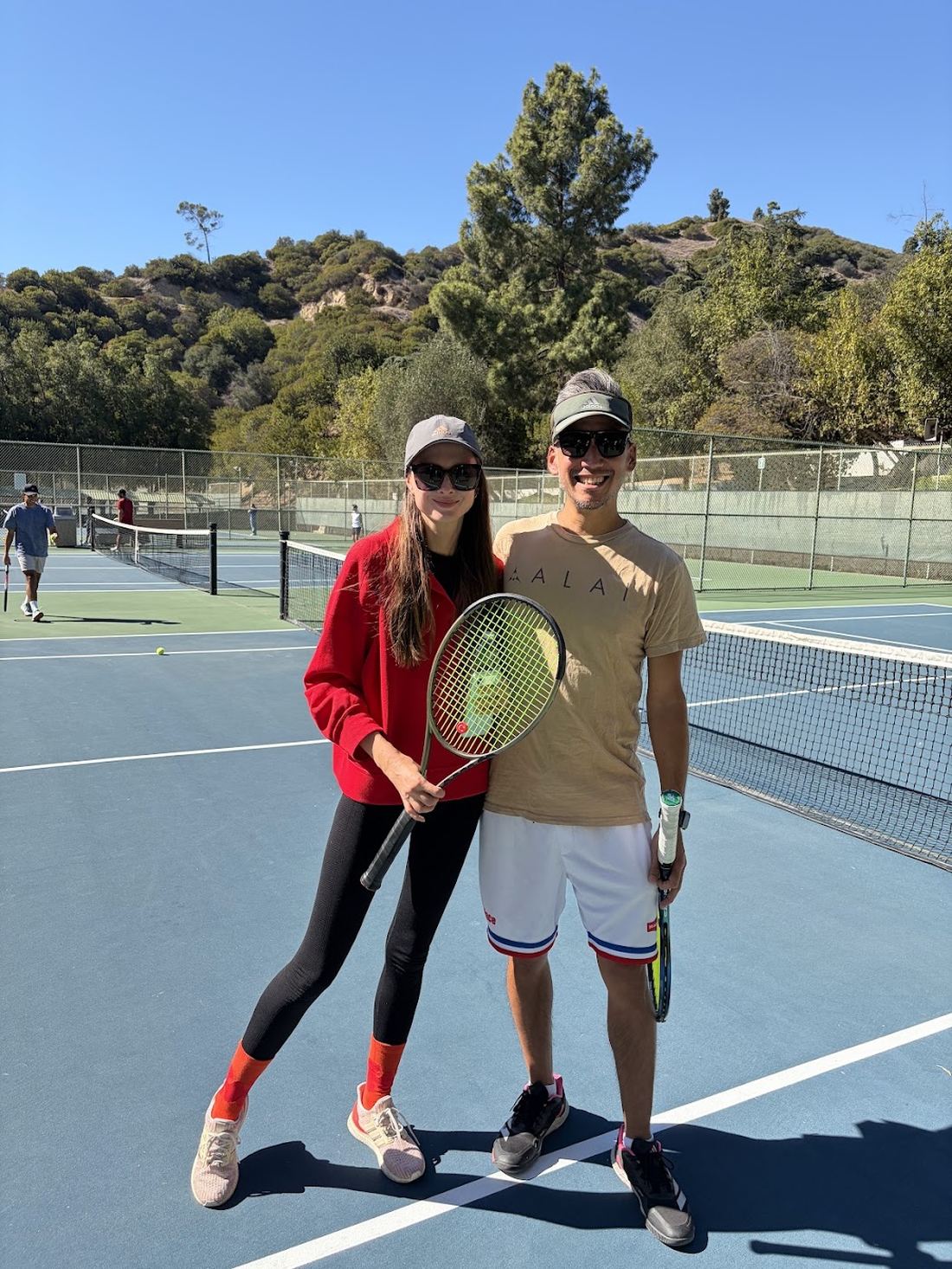 Two players posing with racquets between games.